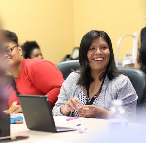 Sahara Estrada Hernandez is all smiles as she works on her résumé during a guest workshop by San Diego Workforce Partnership's CONNECT2Careers program.